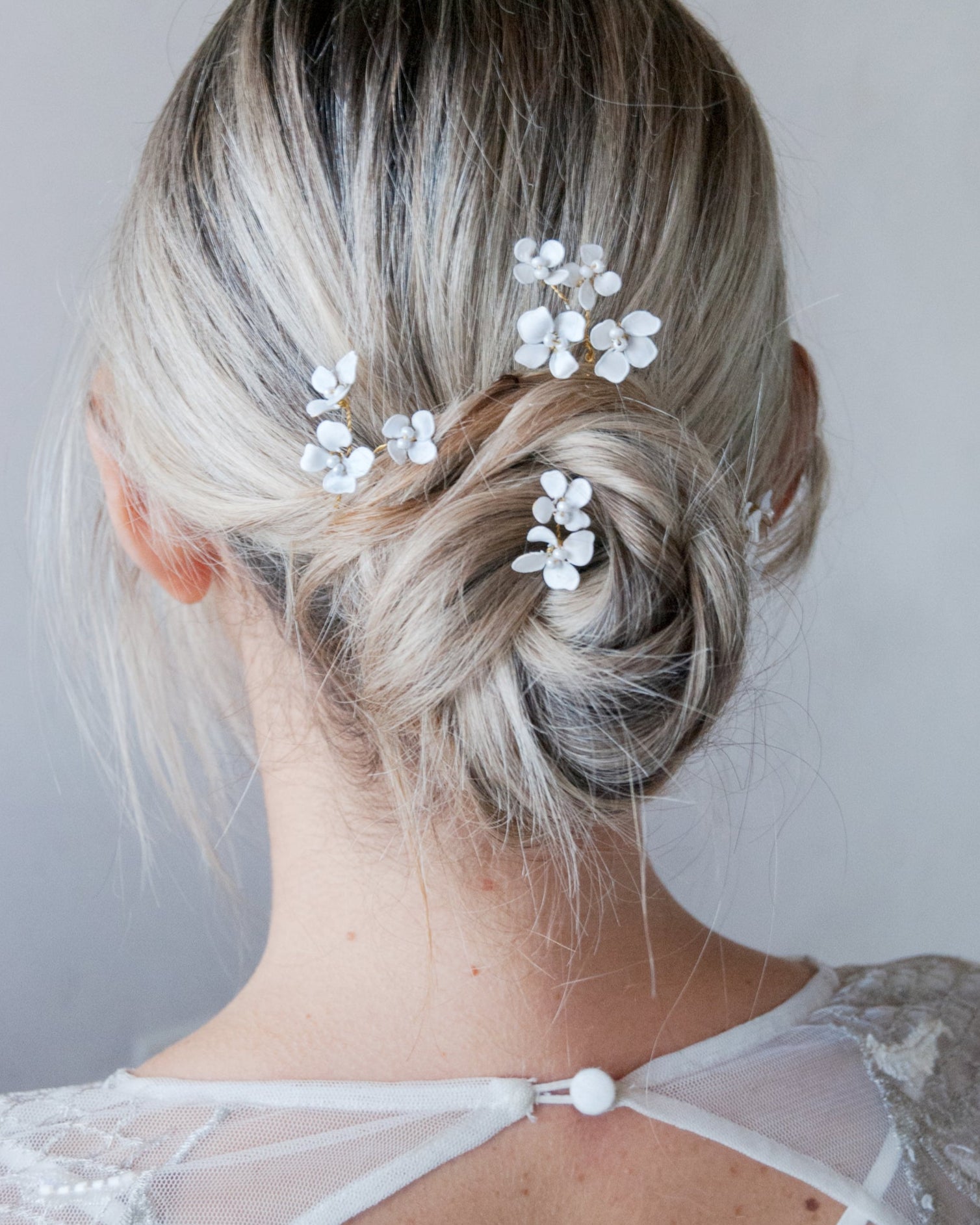 Set di forcine con fiorellini bianchi, ideale per acconciature da sposa raffinate.