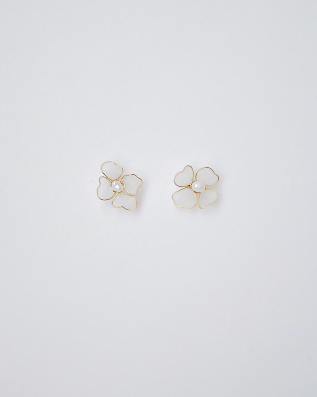 Sposa indossa orecchini fiorellini con perle, accessori matrimonio leggeri e romantici