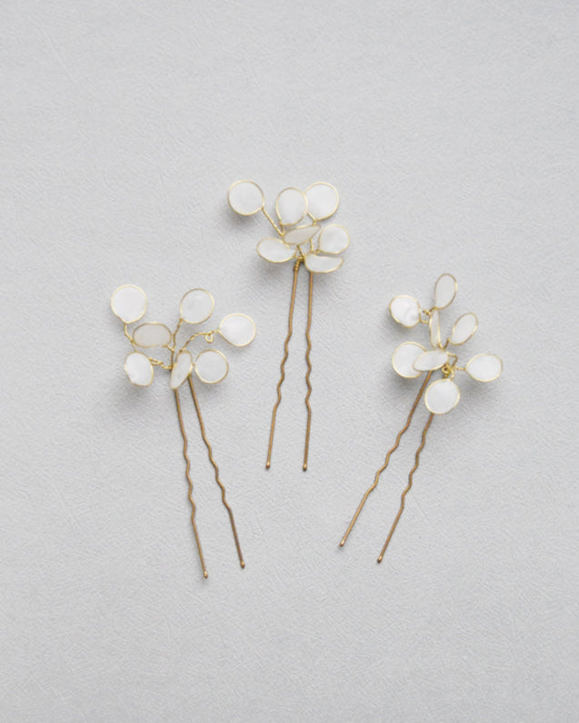 Forcine minimaliste con foglie bianche satinate, per una sposa raffinata.