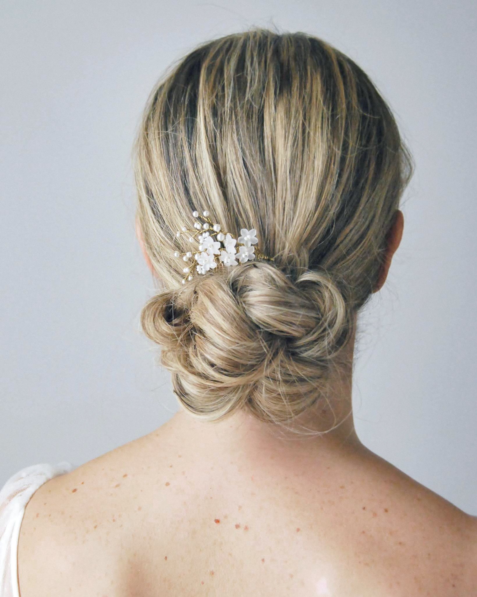 Pettinino con fiori frangipane e perline, perfetto per un look sposa essenziale e luminoso.