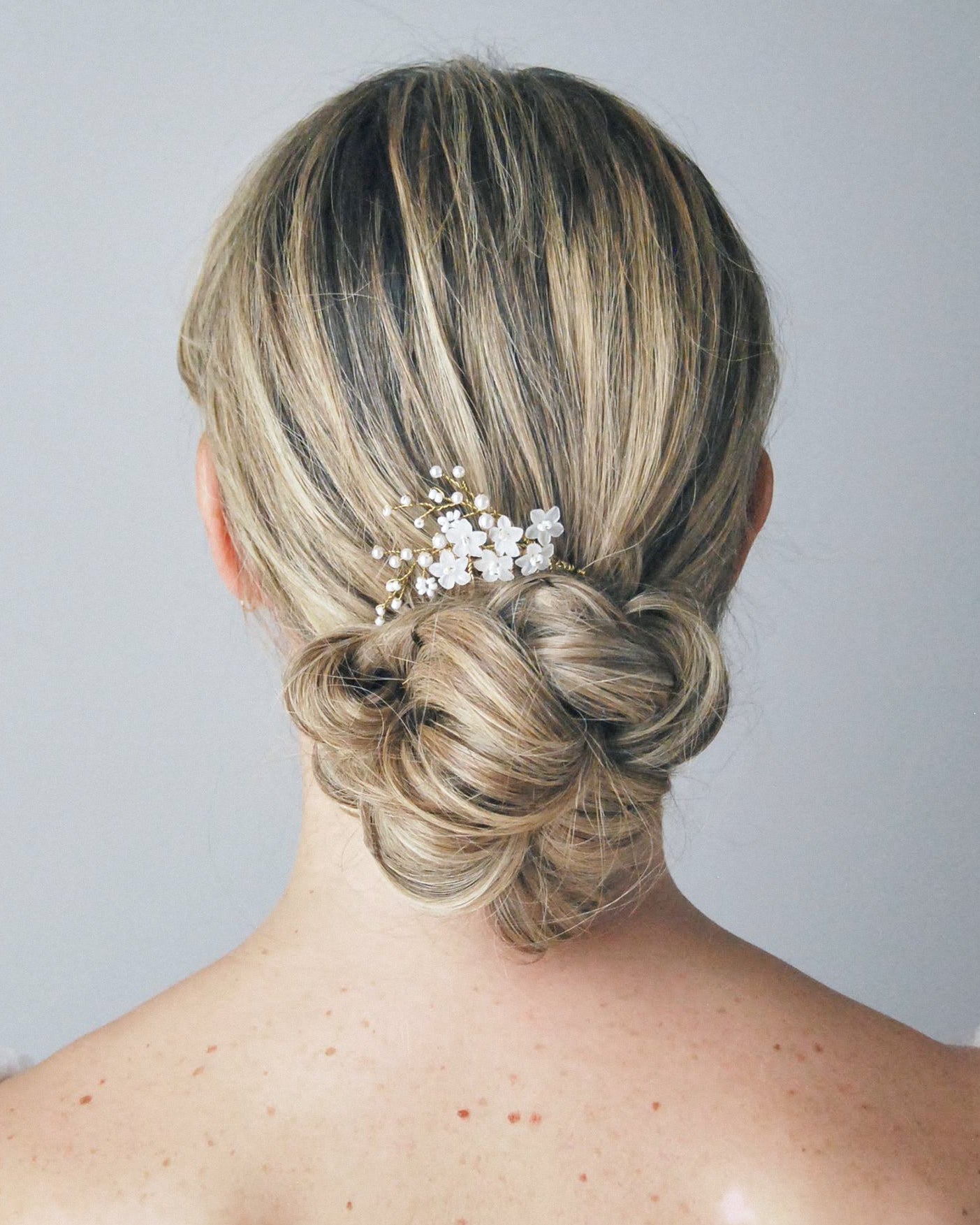 Pettinino sposa con fiori frangipane satinati e perle, perfetto per un’eleganza semplice e naturale.